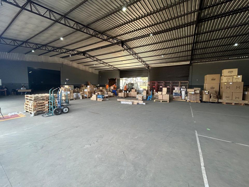 Equipe da PK2U trabalha na triagem entre gaiolas vermelhas e paletes